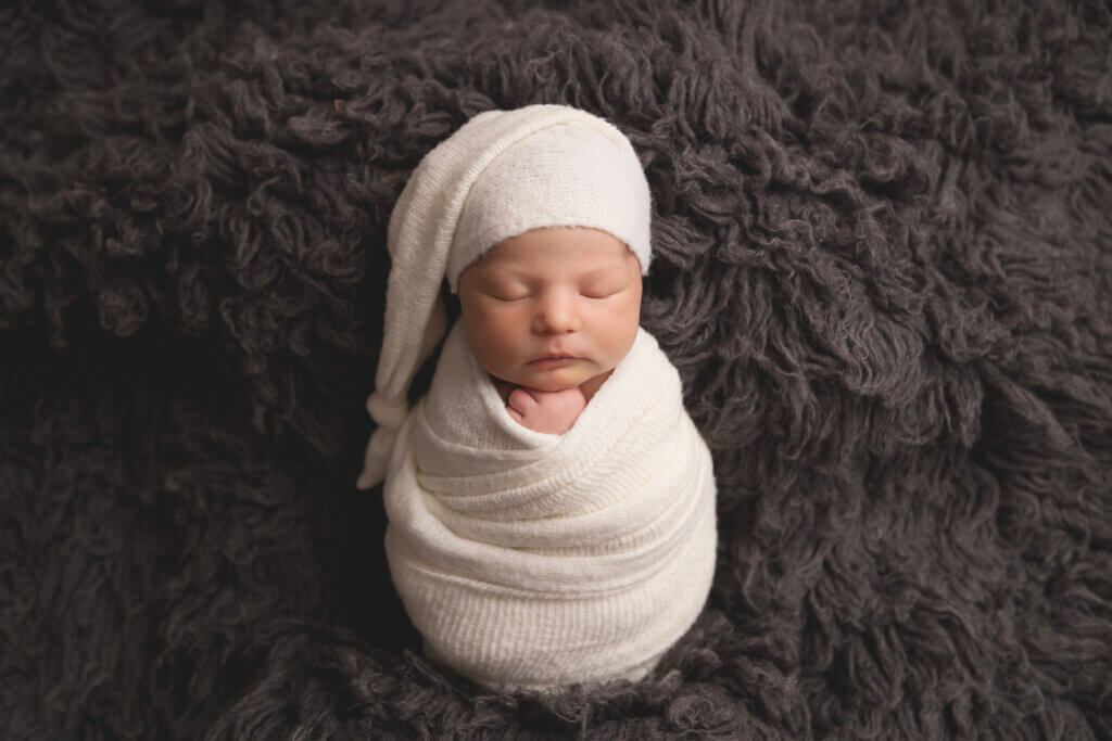 Wrapped newborn with sleepy hat