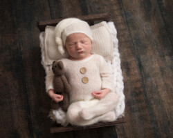 newborn sleeping in bed with bear