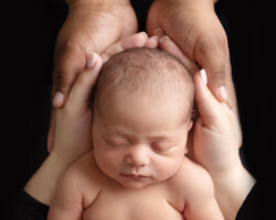 beautiful newborn girl with parents hands