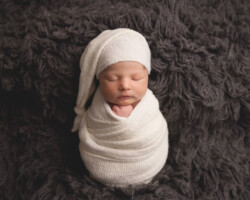 Wrapped newborn with sleepy hat